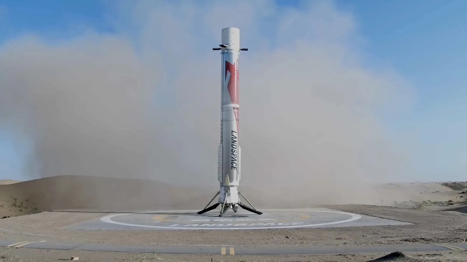 a red and white rocket rests on a landing pad beneath a blue sky